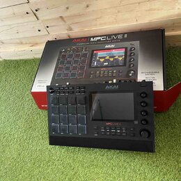 Černý sampler MPC Live II značky AKAI PROFESSIONAL. Zařazení obsahuje 16 gumových padů, displej a ovládací knofíky. Na přístroji je viditelný nápis M…