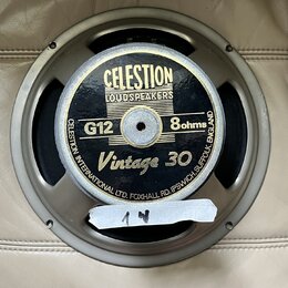 Kruhový reproduktor s kovovým rámem v šedé barvě. Na černém středovém krytu je zlatý nápis CELESTION LOUDSPEAKERS, G12, 8ohms a Vintage 30. Po obvodu…