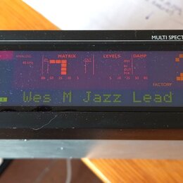 Detailní pohled na černý elektronický přístroj s nápisem MULTI SPECTRAL LCD DISPLAY. Displej zobrazuje červené a zelené texty a grafy, včetně nápisů…