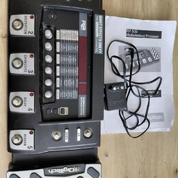 Černý multiefektový procesor s pět vệti spínacími pedály označenými jako COMPRESSOR, DISTORTION, CHORUS/FX, DELAY a REVERB. Na horní části je nápis R…