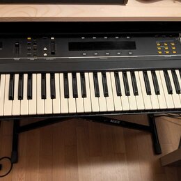 Černý syntetizátor s bílými a černými klávesami. Na levé straně je nápis ESD1 Digital Wave Synthesizer a v pravém horním rohu logo ensoniq. Přístroj…