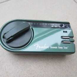 Zelený digitální ladič s připevňovacím klipem. Na přední straně je bílý nápis Fender Chromatic Green Tuner™. Jsou zde vidět tlačítka POWER a A.CALIB…
