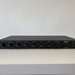 Černý rackový procesor s nápisem Vitalizer a logem spl. Přední panel obsahuje osm otočných ovladačů s popisky DRIVE, BASS SOUND, BASS COMP, MID-HI TU…