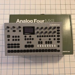 Stříbrný stolní syntetizátor s nápisem Analog Four MKII a logem elektron. Zařízení má černý displej, několik otočných knoflíků a řadu tlačítek v doln…