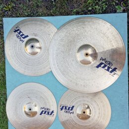 Sada čtyř mosazných činelů značky Paiste z řady pst 3. Na činelech jsou viditelné nápisy paiste a pst 3, přičemž u největšího je uveden text 20 RIDE.…