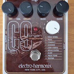 Hnědý kytarový efekt s bílým rámem a nápisem electro-harmonix NEW YORK CITY, USA. Na horní straně jsou čtyři černé ovládací knoflíky s popisky DRY, V…