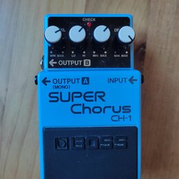 Modrý kytarový efekt s nápisy SUPER Chorus a CH-1. Na spodní části je černý gumový pedal s vyraženým logem BOSS. Horní panel obsahuje čtyři bílé otoč…