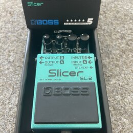 Kytarový efekt Boss SL-2 Slicer v tyrkysovém provedení, umístěný ve své originální černé krabici. Na pedálu jsou viditelné tři ovládací knoflíky a ná…