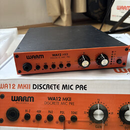 Oranžový mikrofonní předzesilovač s černým vrchem a čelním panelem. Na přístroji i na přiložené krabici je nápis WARM AUDIO WA12 MKII DISCRETE MIC PR…