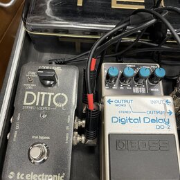 Dvě efektové pedály v černém kufru, propojené kabely. Vlevo je šedý pedál s nápisy „DITTO“, „STEREO LOOPER“, „true bypass“ a logem „tc electronic“. V…