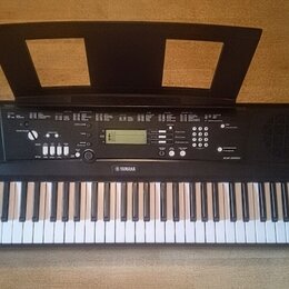 Černý digitální klavír s bílými a černými klávesami. Na přední straně je logo YAMAHA a označení modelu EZ-220. Nástroj má ovládací panel s displejem,…