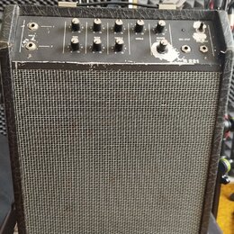 Černý kytarový kombo zesilovač s šedou síťovinou reproduktoru. Na horním ovládacím panelu jsou knofíky s popisky GAIN, BASS, TREBLE, MIDDLE a REVERB,…