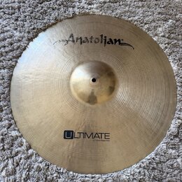 Zlatý kovový činel s viditelným broušením. Na horní části je nápis Anatolian a ve spodní části logo ULTIMATE s doplňujícím textem 22" 55cm Power Ride…