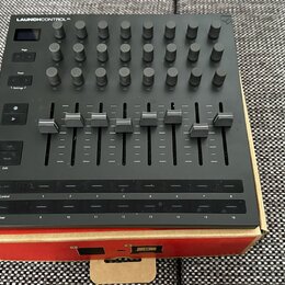 Černý MIDI kontrolér s nápisem LAUNCHCONTROL XL. Horní část obsahuje mřížku šesti řad s otočnými knoflíky, pod nimi je osm posuvníků a v dolní části…