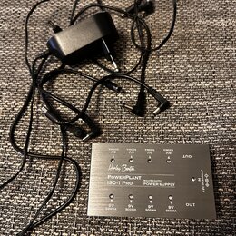 Kovová napájecí jednotka s nápisy „Harley Benton“, „PowerPlant ISO-1 Pro“ a „ISOLATED OUTPUT POWER SUPPLY“. Zařízení má osm výstupů s označením „9V 5…