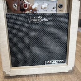 Kytarový kombozesilovač v bílém vinylovém potahu s kovovými rohy. Na předním černém textilním krytu je nápis „Harley Benton“ a v pravém dolním rohu š…