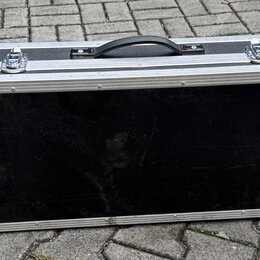Černý transportní kufr s hliníkovými hranami a kovovými rohy. Na horní straně jsou čtyři zapínací zámky a jedna černá plastová rukojeť. V levém dolní…