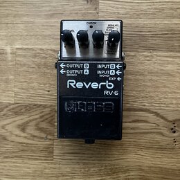 Kytarový efekt reverb v černé barvě s kovovým šasi. Na horní části jsou tři ovládací knoflíky a nápisy CHECK, MODULATE, SPRING, PLATE, HALL, ROOM, SH…