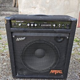 Černý basový kombo zesilovač s látkovým potahem a kovovou mřížkou reproduktoru. Na horním ovládacím panelu je nápis BA150 BASS AMP a v pravé dolní čá…