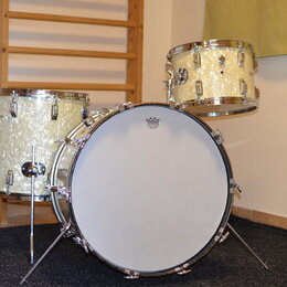 Sada bubnů v krémové perleťové barvě s chromovaným kováním. Na přední bláně basového bubnu je logo „PREMAQ“ a pod ním nápis „Professional Drum BASS D…