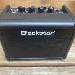Černý kompaktní kytarový zesilovač s nápisem Blackstar na přední mřížce. Na horní ovládací ploše jsou čtyři otočné knoflíky a nápisy FLY, 3 WATT MINI…