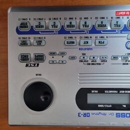 Stříbrný elektronický bicí automat značky BOSS, model Dr. Rhythm DR-3. Zařízení má horní panel s modrými a šedými tlačítky, ovládací knoflík VALUE a…