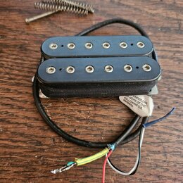 Černý humbucker s dvěma řadami šesti polových magnetů. Na spodní straně je viditelná bílá nálepka s nápisem UNDER ONE OF THE FOLLOWING U.S. PATENTS:.…