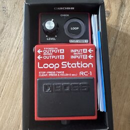 Červený kytarový pedál Boss Loop Station RC-1 v originální černé krabici s přiloženou dokumentací. Na horní části je ovládací knoflík LEVEL, tlačítko…