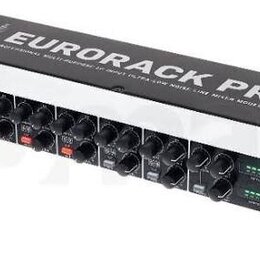 Stříbrný rackový mixér s černým ovládacím panelem a řadou černých otočných knoflíků. Na horní části je nápis EURORACK PRO a pod ním text PROFESSIONAL…