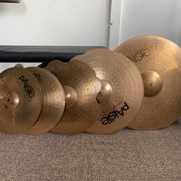 Sada pěti mosazných činelů různých velikostí. Na několika činelech je vidět logo Paiste a označení Zildjian 2002. Povrchy činelů vykazují známky použ…