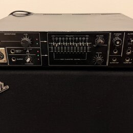 Černý rackový přístroj s nápisem Roland VOCODER SVC-350 položený na černém kombu značky Fender. Přední panel obsahuje různé přepínače, potenciometry…