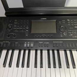 Černý digitální klavír značky YAMAHA s modelem PSR-S. Nástroj má standardní klávesnici a ovládací panel s displejem, několika tlačítky a dvěma otočný…