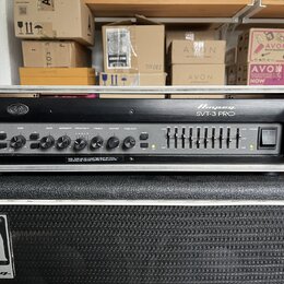 Černý basový zesilovač v kovovém šasi s nápisem Ampeg SVT-3 PRO. Přední panel obsahuje ovládací knofíky s popisky INPUT, GAIN, BASS, MIDRANGE, FREQUE…
