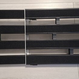 Fotografie zobrazuje dva obdélníkové pedály do efektového pedalboardu. Jsou vyrobeny z hliníku s černými protiskluzovými gumovými pásy. Na povrchu ne…