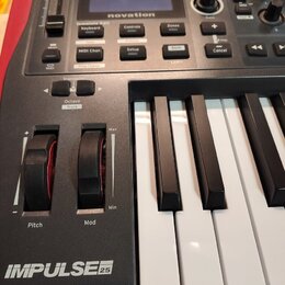 Černý MIDI kontrolér s klávesami. Na horní části je displej a nad ním nápis novation, dále řada tlačítek s popisky jako Template Edit Keyboard, Contr…