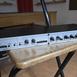 Rackové zařízení s bílým předním panelem a černým šasi. Na levé straně je logo dbx PROFESSIONAL PRODUCTS, vpravo nápis 286s Mic Preamp Processor. Pan…