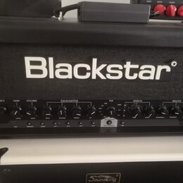 Černý kytarový kombozesilovač značky Blackstar. Na předním panelu jsou nápisy V-VOICE, GAIN, VOLUME, EQUALISATION, TVP, EFFECTS a MASTER, dále označe…