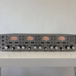 Stříbrný rackový mikrofonní předzesilovač s čtyřmi kanály. Na levé straně je nápis TONE-BLENDING 4-710d MIC PREAMPLIFIER a vpravo logo UA UNIVERSAL A…