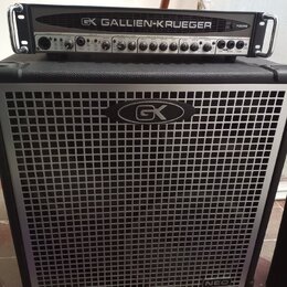 Černý basový zesilovač s hlavou a reproduktorovou skříní. Na hlavě je nápis GK GALLIEN-KRUEGER a označení modelu 700RB. Přední mřížka skříně je stříb…