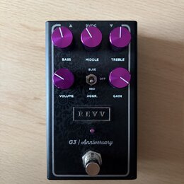 Kytarový efekt pedál v černé barvě s fialovými ovládacími knoflíky. Na horní straně jsou nápisy BASS, MIDDLE a TREBLE, ve střední části VOLUME, AGGR.…