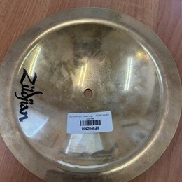 Kulatý mosazný činel s logem Zildjian. Na povrchu je nalepená bílá štítková nálepka s čárcovým kódem a textem ZILDJIAN 9-5" 24 bell large A20002 pouz…