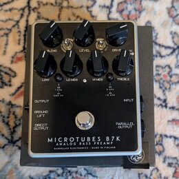 Černý basový předzesilovač v kovovém šasi s nápisy MICROTUBES B7K, ANALOG BASS PREAMP a DARKGLASS ELECTRONICS - MADE IN FINLAND. Zařízení má sedm čer…