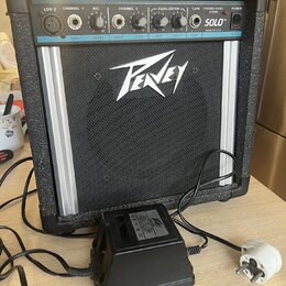 Černý přenosný kombozesilovač s logem Peavey na předním mřížkovém krytu. Horní ovládací panel obsahuje nápisy LOW Z, CHANNEL 1, MIC, CHANNEL 2, EQUAL…