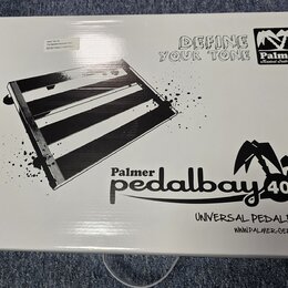 Bílá papírová krabice s černými nápisy a grafikou. Na povrchu je obrázek pedalboardu a texty „DEFINE YOUR TONE“, logo „Palmer Musical Instruments“ a…