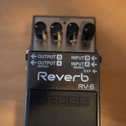 Kytarový efekt pedál značky BOSS, model RV-6 Reverb. Zařízení má černé kovové šasi s bílými nápisy OUTPUT B, OUTPUT A (MONO), INPUT B, INPUT A (MONO)…