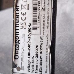 Detailní záběr na bílý štítek s technickými specifikacemi nalepený na černém povrchu. Na štítku je svisle napsáno Octagonheater a STAIRVILLE, dále úd…