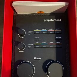 Černý zvukový interface značky propellerhead v červené krabici. Zařízení má dva menší ovratidla s popisky 1/LEFT a 2/RIGHT, dvě velká ovratidla MAIN…