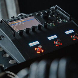 Černý kytarový procesor s nápisem FM3 AMP MODELER / FX PROCESSOR. Zařízení má digitální displej, několik ovládacích knoflíků a tři podsvícená tlačítk…
