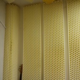 Fotografie zobrazuje akustické pěnové panely s voštinovou strukturou v krémové barvě. Panely jsou umístěny na stěnách a stropě místnosti. V levé část…