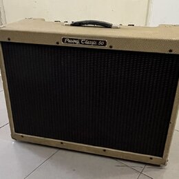 Kytarový kombo zesilovač s béžovým potahem z textilie a černou mřížkou reproduktoru. Na horní části je nápis Peavey Classic 50 v oválném rámečku. Hor…